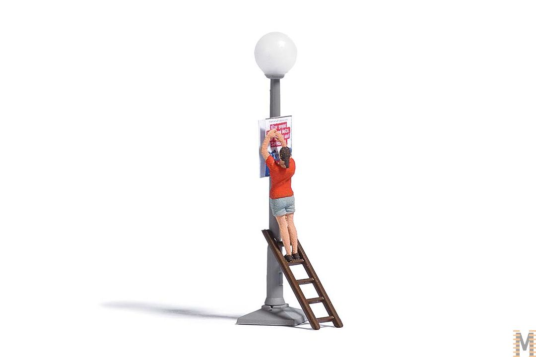 Dame sur échelle accroche une affiche sur un réverbère (inclus)