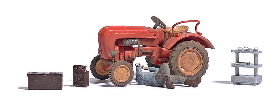 Tracteur en panne avec un reparateur couch une desserte et caisse  outils et un jerycan de carburant