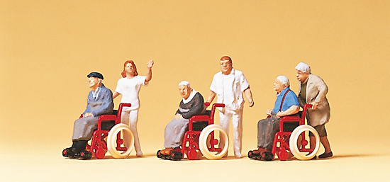 3 personnes ages en fauteuils roulants avec personnel soignant