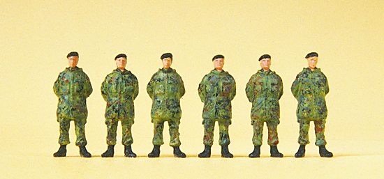 6 soldats avec bérets bleus debouts en tenue de camouflage