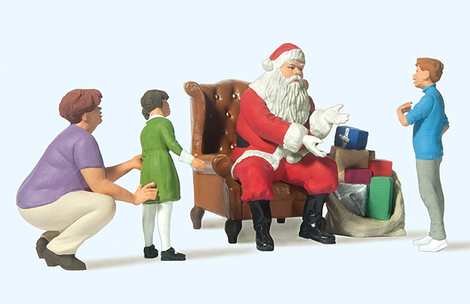 Père Noël dans un fauteuil‚ maman avec fillette et garçonnet‚ nombreux cadeaux