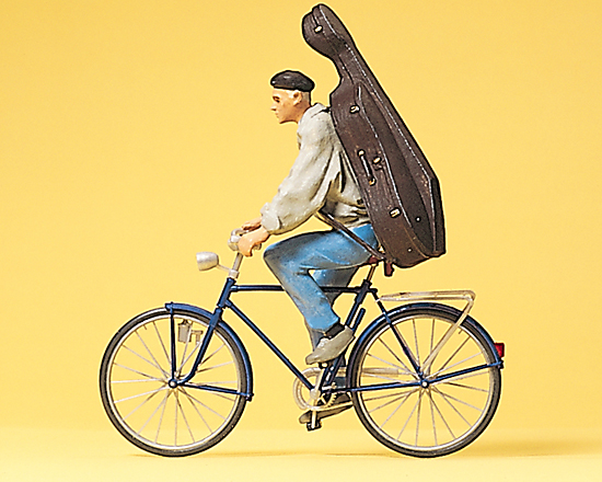 Jeune homme à vélo avec violoncelle sur le dos
